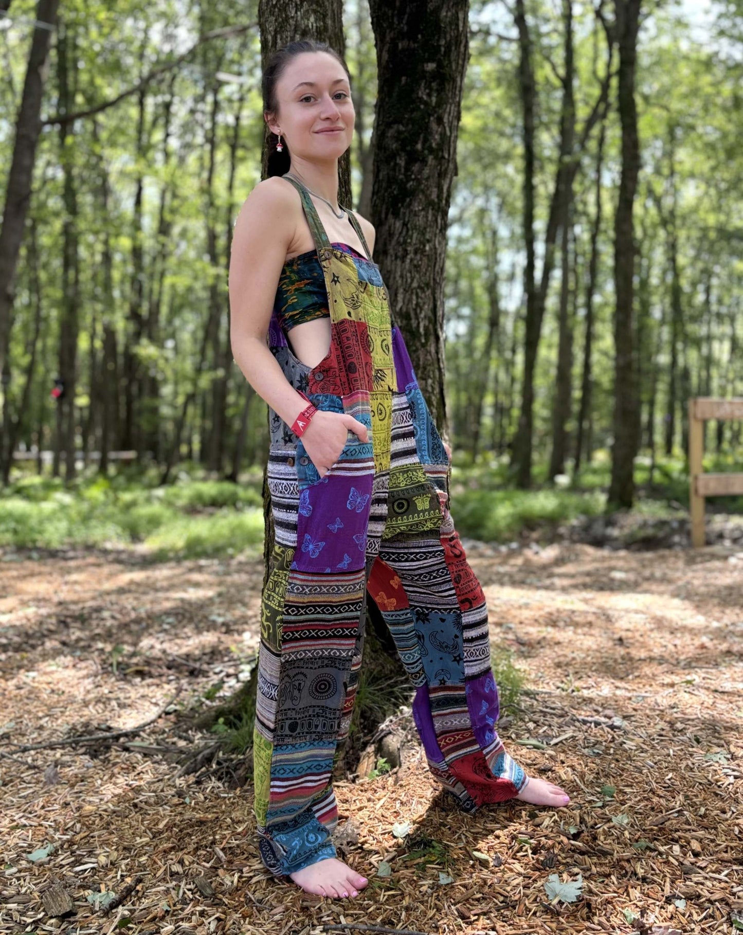Multi Color & Ikat Patchwork Overalls with vibrant print in a forest setting.