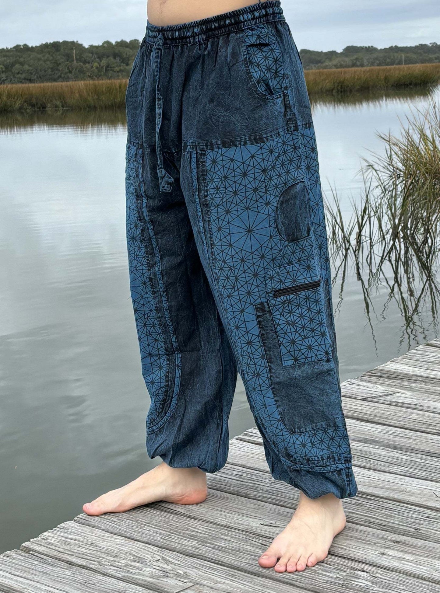 Stone washed pants with elastic cuffs and drawstring waist, featuring six pockets and breathable cotton fabric.