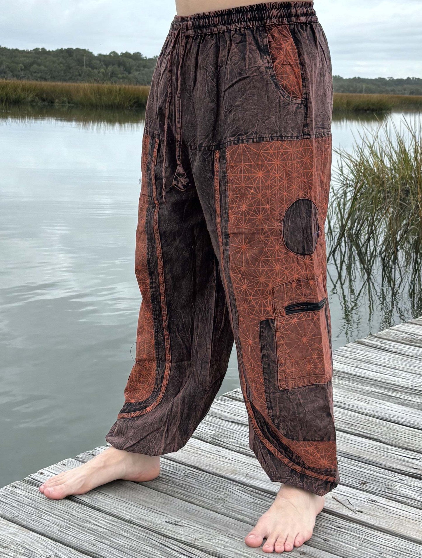 Stone washed pants with six pockets and elastic cuffs, outdoor setting.