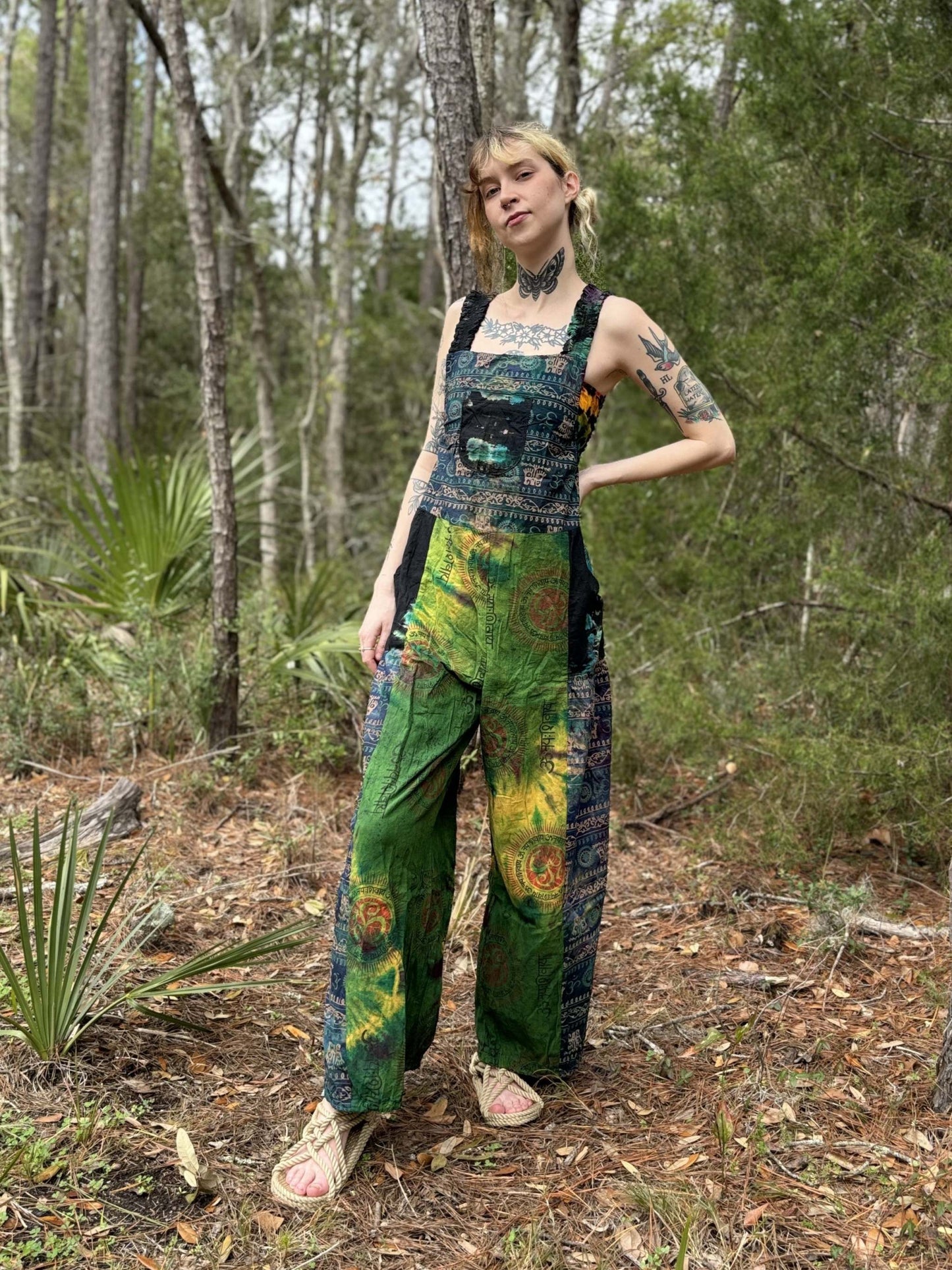 Tye-dye pallazzo overalls with adjustable straps, harem legs, handcrafted in cotton, modeled in a forest setting.