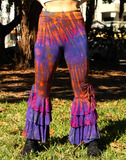 Ruffle bottom pants in vibrant dye patterns with tiered ruffles and a form-fitting design.