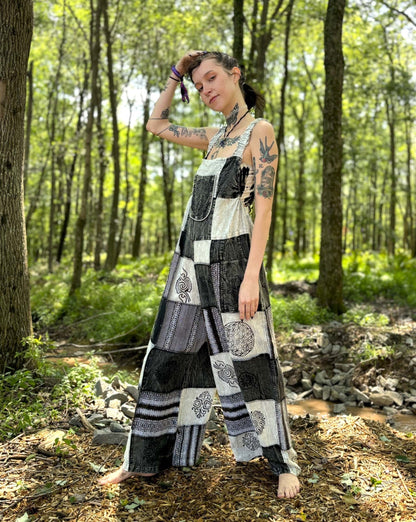 Black & White Patchwork Overalls with palazzo legs and adjustable straps in a forest setting.