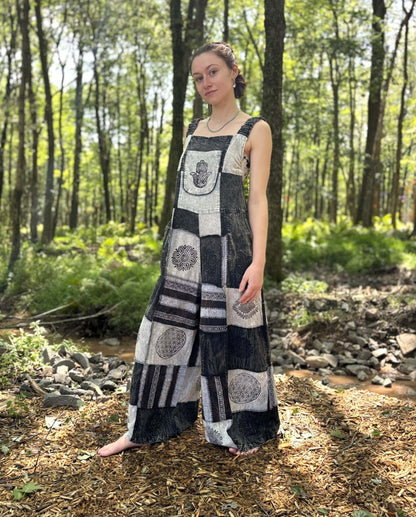 Black & White Patchwork Overalls with hand-printed patches and adjustable straps in forest setting.