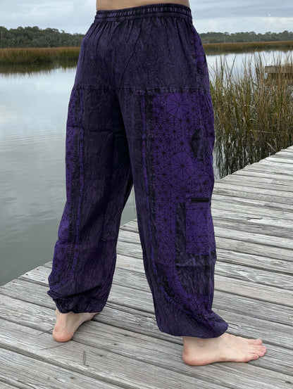 Stone washed pants with six pockets and elastic cuffs on a wooden dock.