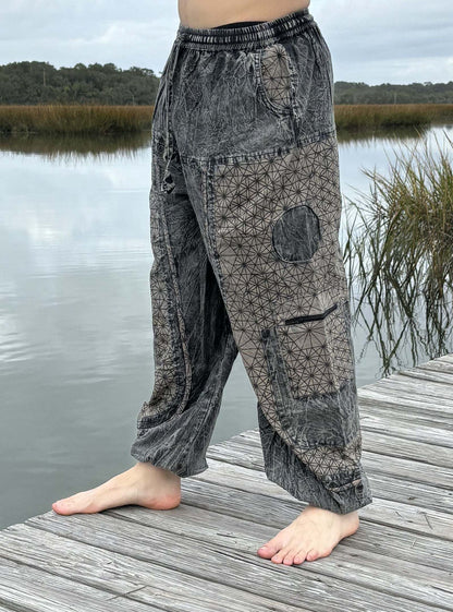 Stone washed pants with six pockets and elastic cuffs by a lake.