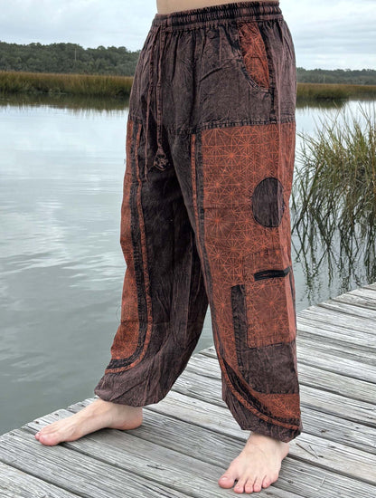 Stone washed pants with six pockets and elastic cuffs, outdoor setting.
