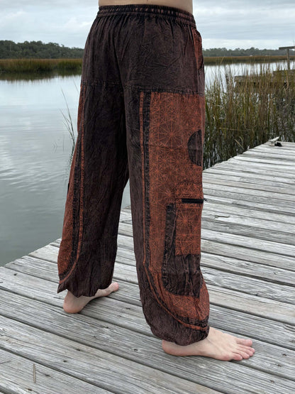 Stone washed pants with elastic cuffs and zipper pockets by a lakeside.