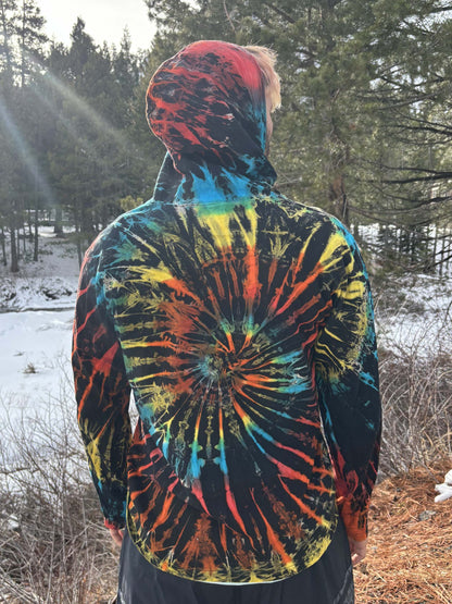 Light tie-dye hoodie with vibrant, unique patterns in a natural outdoor setting.