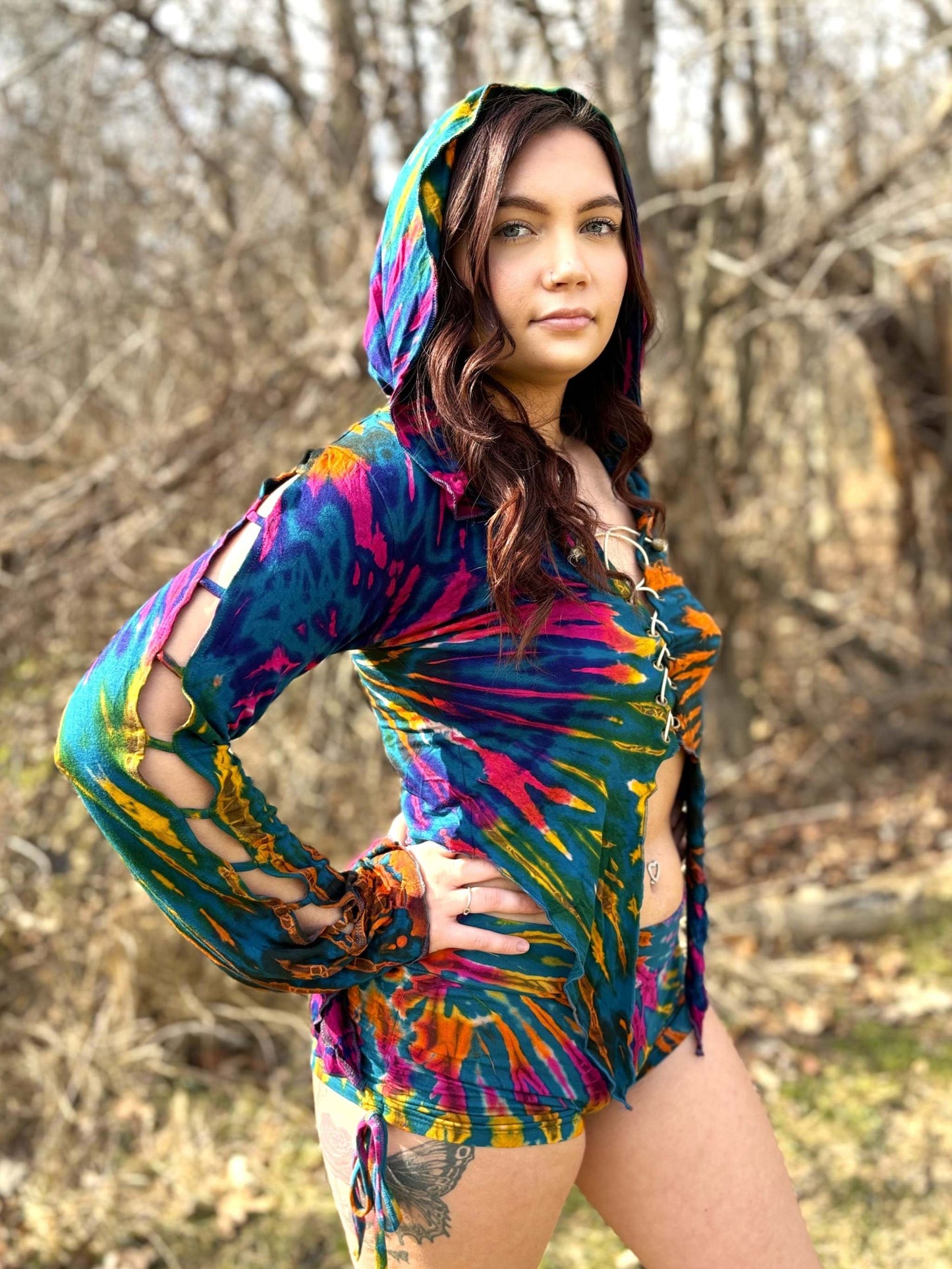 Vibrant Calypso top with elven hood, flowing sleeves, and laced front, showcasing a unique multicolored pattern.