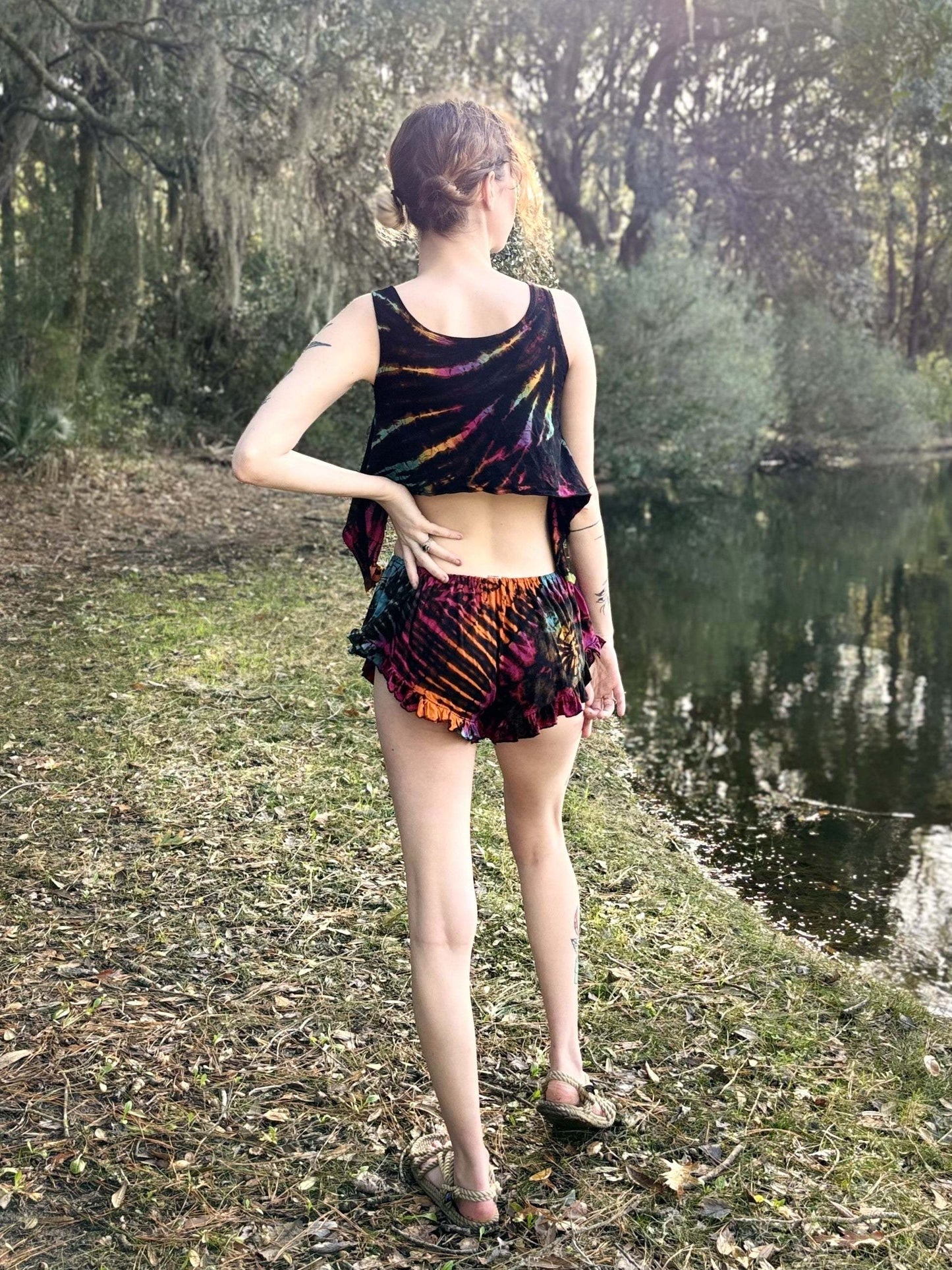 Colorful ruffle booty shorts worn outdoors by a lake.