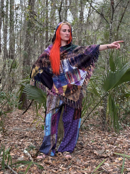Colorful Tye-Dye Patchwork Poncho worn by a model in a forest setting, showcasing handcrafted design and wooden toggle buttons.