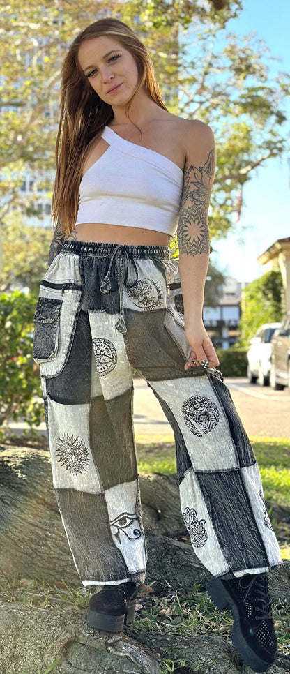 Woman wearing Xenos Patchwork Pants with unique hand-printed designs and elastic waistband.