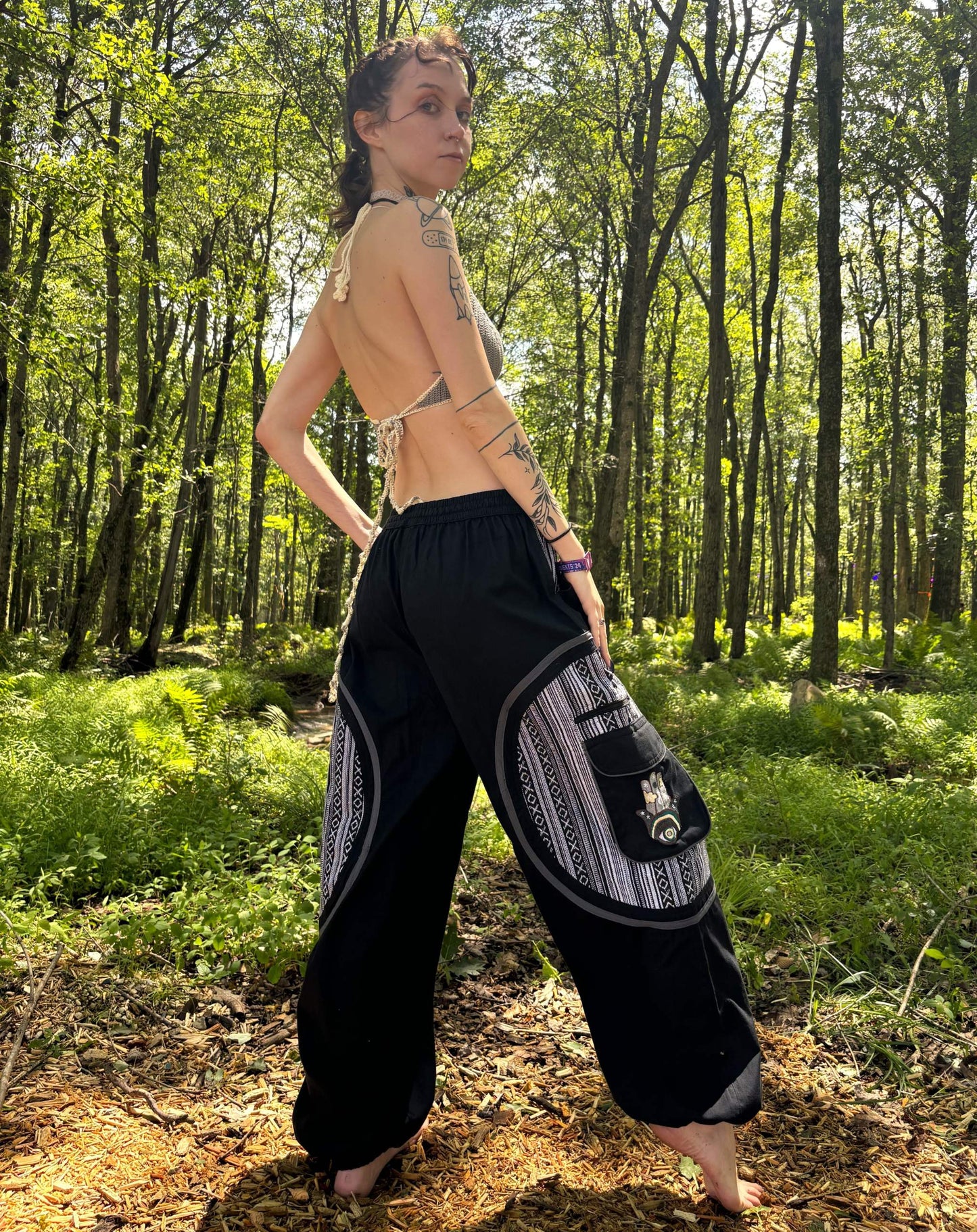Handmade Hamsa Ikat Harem Pants in forest setting, showcasing ethnic pattern.